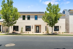 A two-story building with a flat roof, large windows, and a door with a glass panel. - Brand New Home! Its about time to have a beautiful pool area, spacious 7 bedroom home. (Hurricane)