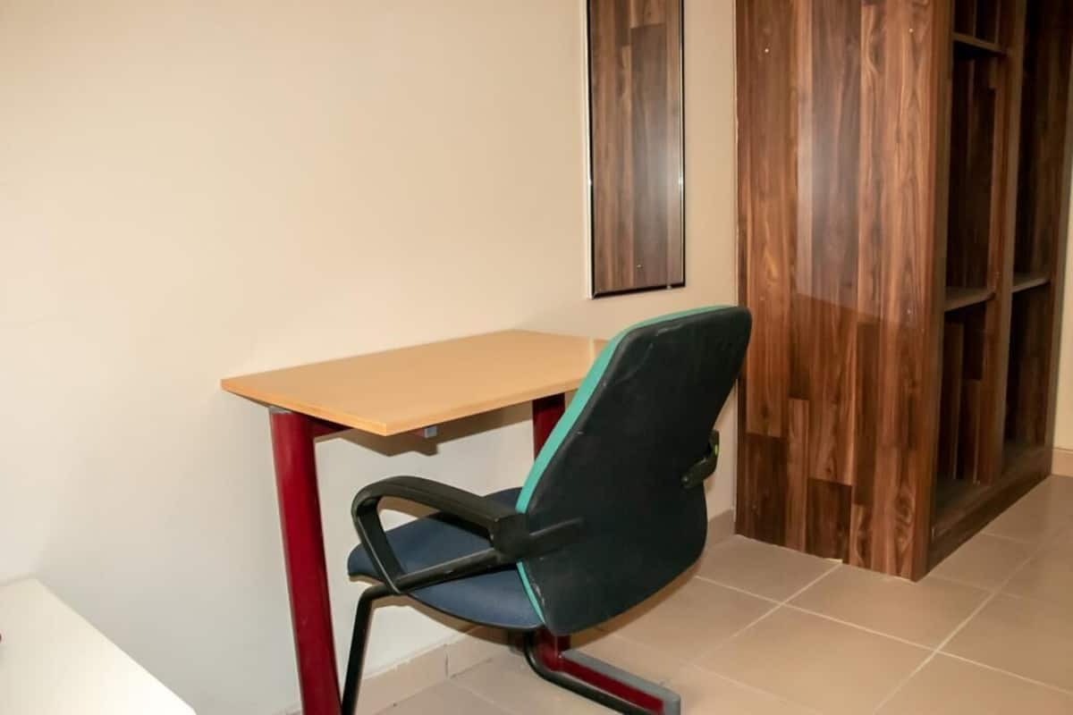 Una habitación pequeña y sencilla con un escritorio de madera y una sola silla.