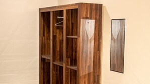 A corner wardrobe with multiple shelves and hanging space, built into a wall.