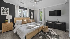 A bedroom with a bed, nightstands, a television, and a ceiling fan. - Hot Tub-Sauna-Bar-Gym-4BR-Sleeps 8 (Columbus)
