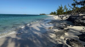 A beach with clear turquoise water, white sand, and rocky outcrops. - Cottage 6 - Charming 1-bedroom cottage-pool-tennis-walk to beach in Sandy Point (Sandy Point)