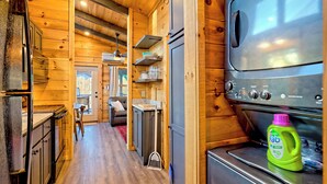 A compact kitchen with wooden walls, a built-in oven, and a refrigerator.