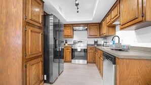 Une cuisine moderne avec des meubles en bois, des appareils en acier inoxydable et un lave-vaisselle.