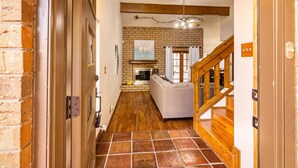 A hallway with a fireplace, a sofa, and a staircase. - Cozy Home w/Private Patio, KingBed, Fireplace, BBQ (El Paso)
