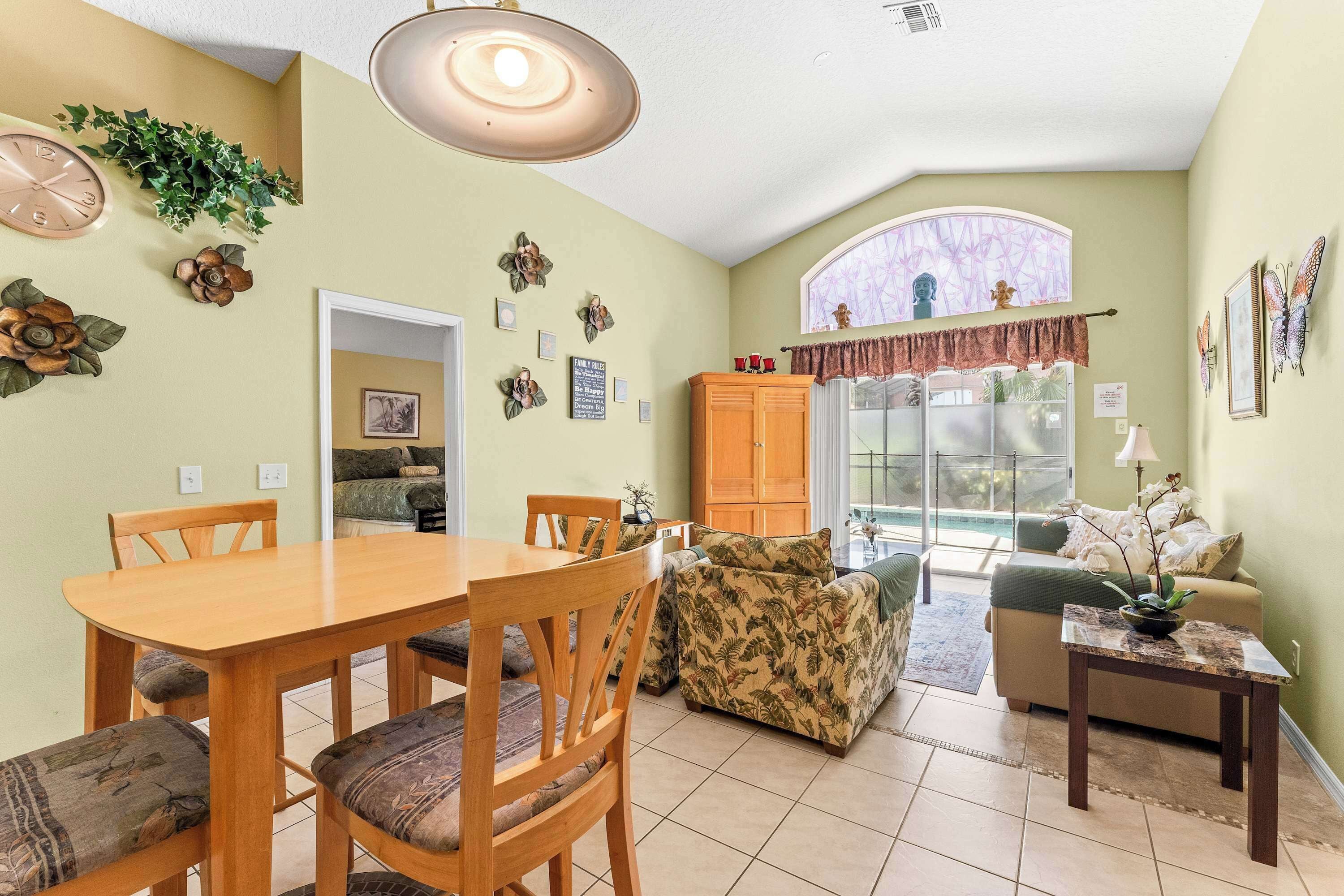 A dining area with a wooden table and chairs, a sofa, and a cabinet.