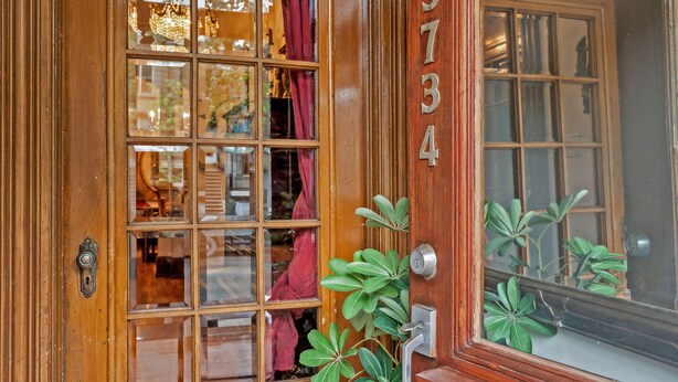 A wooden door with a glass panel and a number "374" on the door frame.