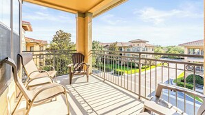 A balcony with three lounge chairs, a view of a residential area, and a clear sky. - Tuscan Paradise At Bella Piazza (Davenport)