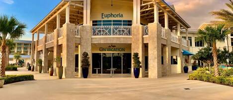 A hotel with a central atrium, balconies, and a sign for 'Euphoría' and 'On Vacation'.