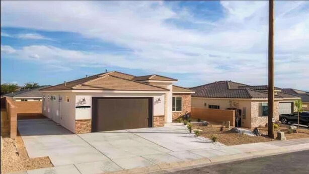A residential area with two houses, each with a garage and a driveway.