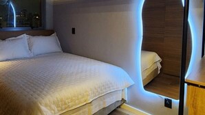 A bedroom with a bed, a window, and a unique wall design.