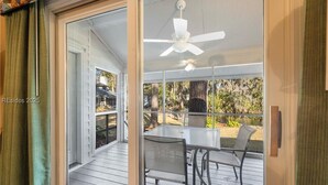 A covered patio with a table and chairs, a ceiling fan, and a view of the outdoors. - Brigantine Quarters 3BR/3.5BA in Shipyard, Private Beach Gate, 2 Pools and MORE (Hilton Head Island)