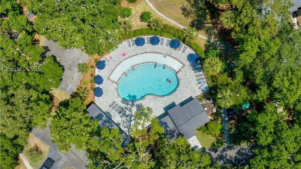 An aerial view of a residential property with a swimming pool surrounded by a deck, trees, and a house. - Brigantine Quarters 3BR/3.5BA in Shipyard, Private Beach Gate, 2 Pools and MORE (Hilton Head Island)