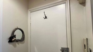 A white door with a simple metal hook and a doorbell. - Stunning 1-bed Flat W/seaview, Garden Pet Friendly (Herne Bay)