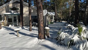 A snow-covered landscape with a house, a gazebo, and a birdbath. - Adorable 2 Bedroom Unit with Boat Parking (Dauphin Island)