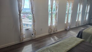 Habitación de hotel con una cama grande, una mesita de noche y una ventana con cortinas estampadas.