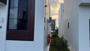 A modern building with a narrow courtyard, large windows, and a patterned floor. - 3Bed-3Bath Villa in Beautiful Punta Cana with AC (Punta Cana)