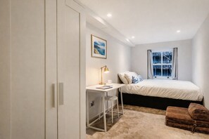 A bedroom with a bed, a desk with a chair, a window, and a door. - The Hyde Park Elegant Executive Residence (London)