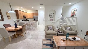A spacious living room with a dining area, a kitchen in the background, and a staircase leading to an upper level. - SW FL Vacation Paradise! Minimum 1 week stay, long term renters welcome.  (Fort Myers)