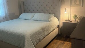 A bedroom with a bed, a ceiling fan, a bedside table with a lamp, and a framed picture on the wall. - We Are…..2 miles from Beaver Stadium! (State College)
