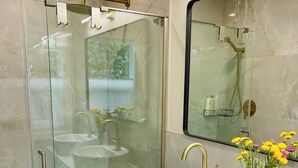 A modern bathroom with a glass-enclosed shower, two sinks, and a large mirror. - Cozy Studio downtown Carson, near Tahoe/Reno (Carson City)