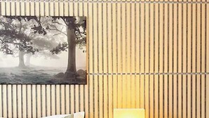 A bedroom with a bed, a bedside table with a lamp, and a wall-mounted artwork of trees. - Cozy Studio downtown Carson, near Tahoe/Reno (Carson City)