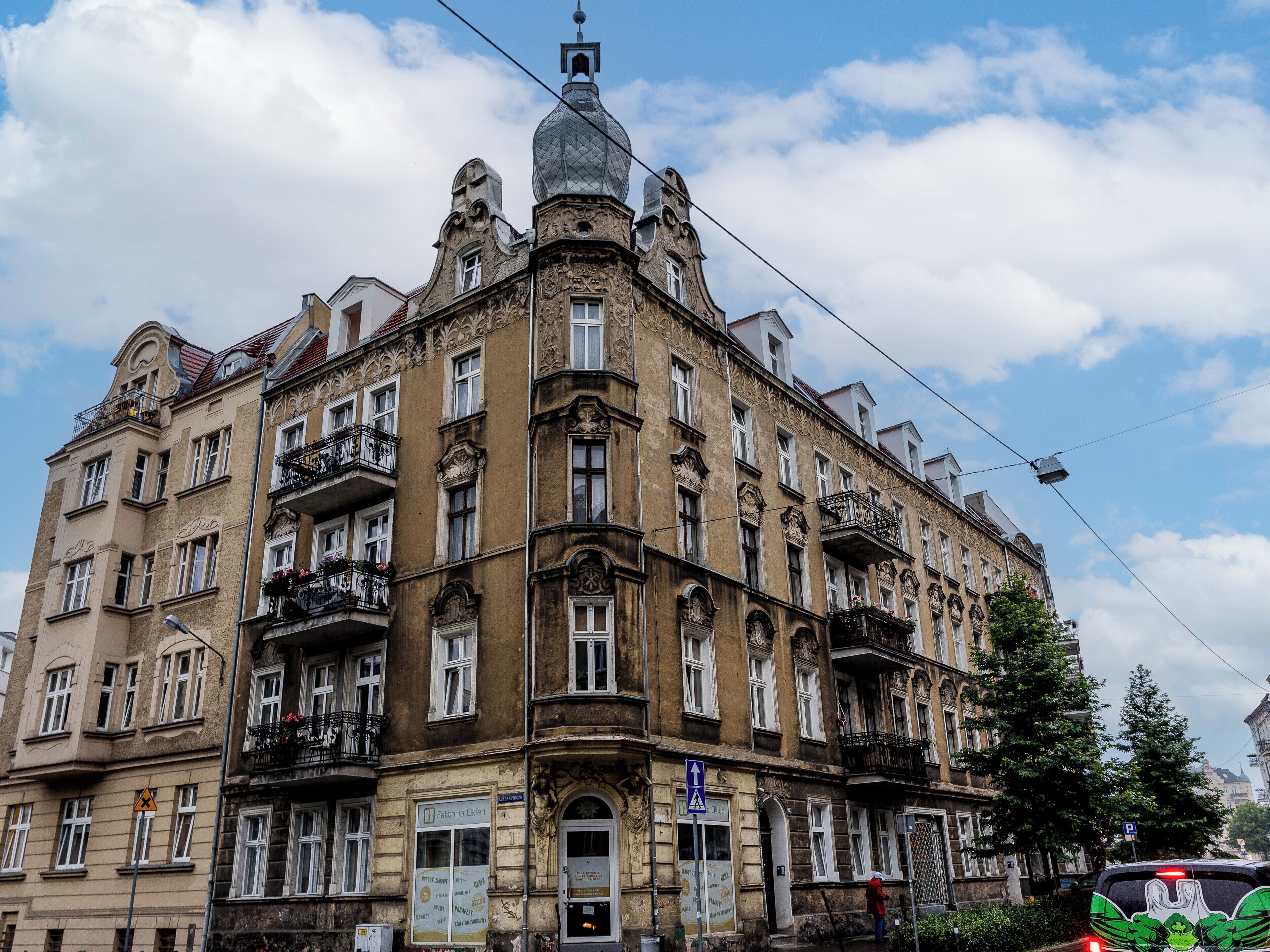 Un edificio histórico con detalles arquitectónicos ornamentales, múltiples balcones y una imponente torre en esquina.