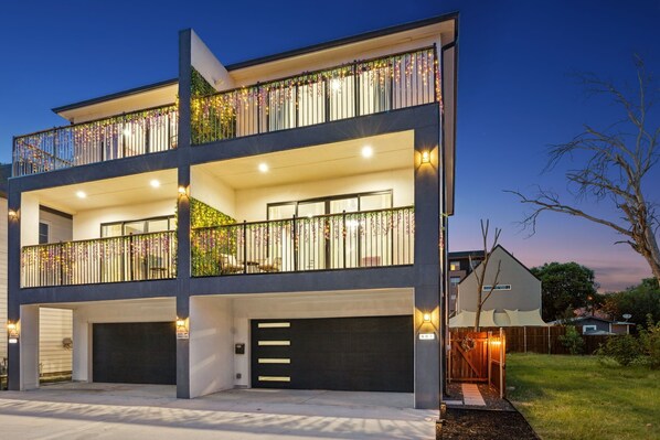 A modern two-story house with a covered garage, a balcony with decorative railings, and a well-lit exterior. - Casa Verde Balcony 4 Bedrooms in Downtown Dallas. (Dallas)