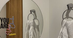 A bathroom with a wooden door and a towel hanging on a metal towel ring. - Autenthico Local Stay Hotel Envigado (Envigado)