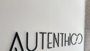 A wall with the word "AUTHENTICO" in a modern, stylized font.
