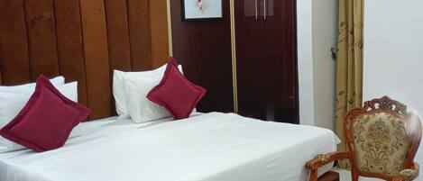 A neatly arranged bedroom with a wooden bed, a chair, and a small table.
