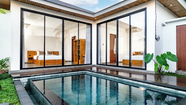 Een modern huis met een zwembad, grote glazen deuren en een houten interieur.