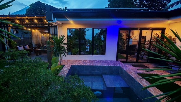 A modern house with a patio, outdoor seating, and a swimming pool.