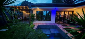 Une maison moderne dotée d’un patio, d’un espace salon extérieur et d’une piscine.