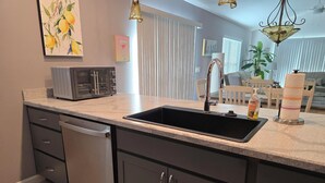 A modern kitchen with a built-in dishwasher, a double sink, and a toaster. - Beautiful, well appointed, 3-bed house in DeLuna - 2 Kings! (The Villages)
