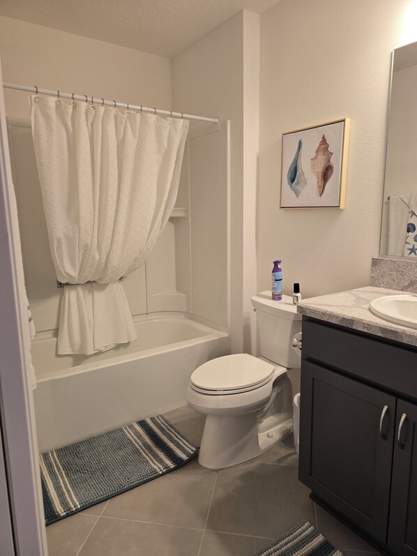A bathroom with a bathtub, toilet, and sink.