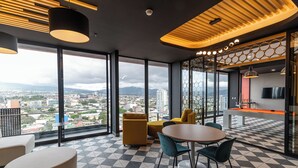 A modern interior with large windows, a dining area, and a view of the city. - Luxury apartment full equip. in San Jose with balcony city views & top amenities (San José)
