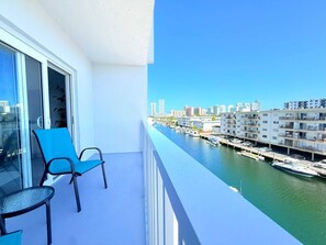 Ein Balkon mit Blick auf einen Jachthafen und die Skyline der Stadt.