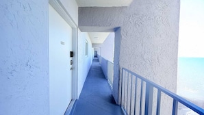 A corridor with a blue floor, white walls, and a balcony railing. - Top Location Waterfront Balcony Dream (North Miami Beach)