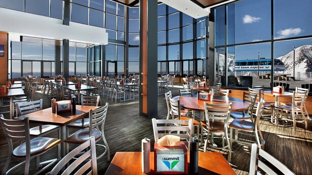 A spacious dining area with high ceilings and large windows, offering views of a mountainous landscape and a bus. - Snowbird Ski In/Out Cliff Club w/ private Hot Tub (Snowbird)