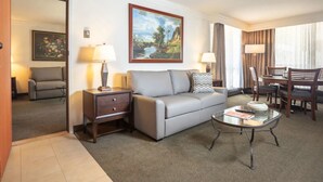 A hotel room with a sofa, a glass coffee table, a dining table with chairs, a painting on the wall, and a lamp. - Snowbird Ski In/Out Cliff Club w/ private Hot Tub (Snowbird)