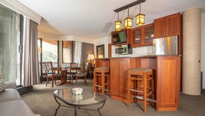 A hotel room with a kitchenette, a dining area, and a seating area with a glass coffee table. - Snowbird Ski In/Out Cliff Club w/ private Hot Tub (Snowbird)