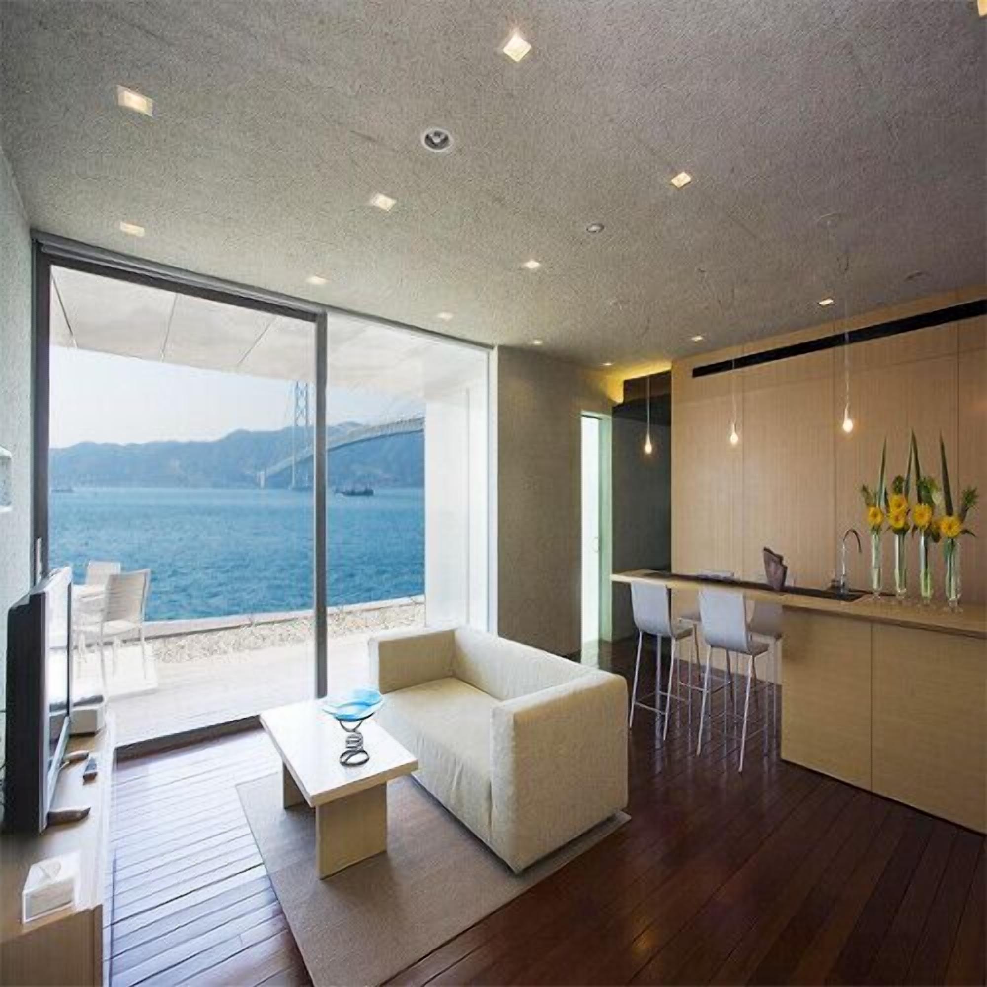 A modern interior with a sofa, dining area, and kitchen.