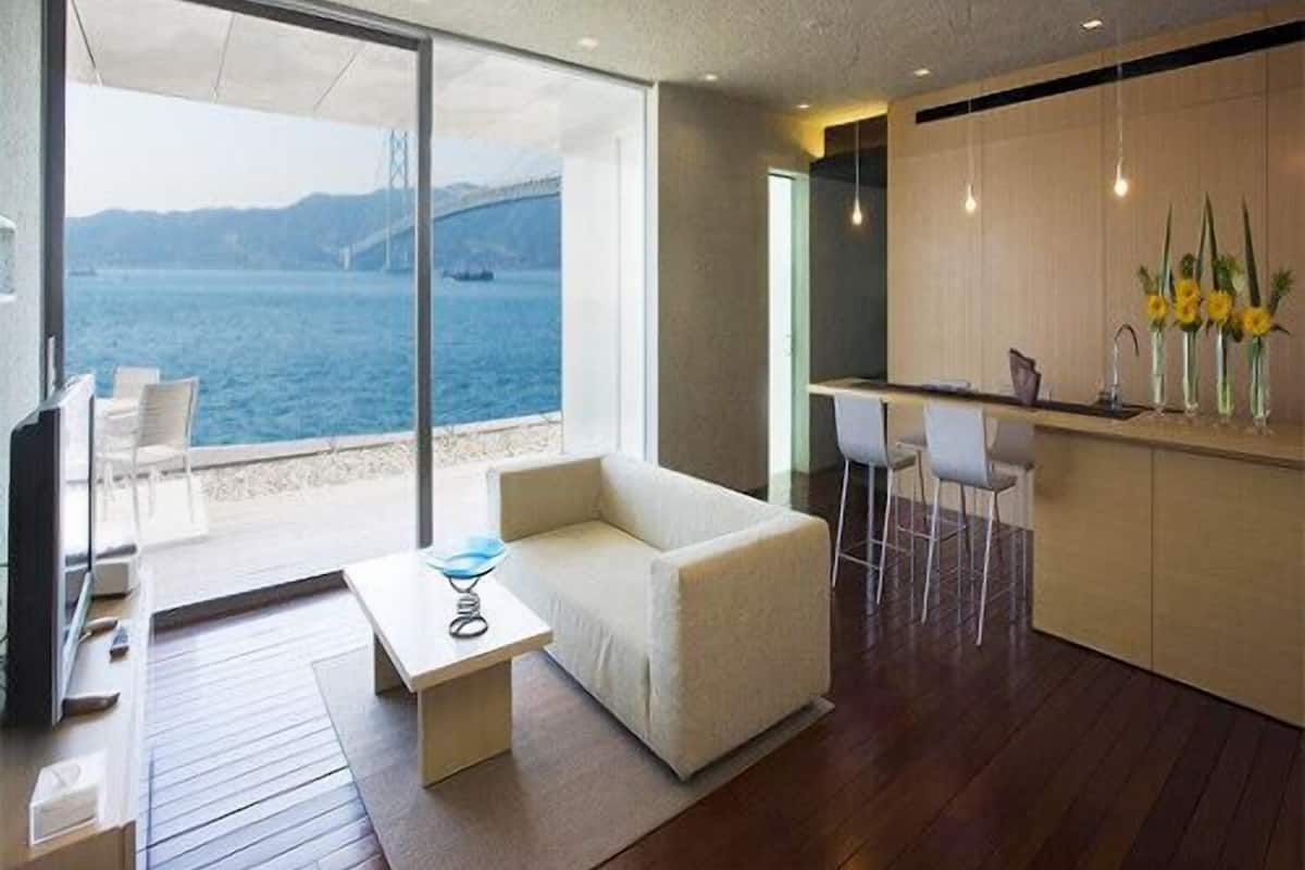 Un intérieur moderne comprenant un canapé, un coin repas et une cuisine.