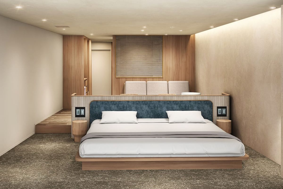 A modern bedroom with a bed, nightstands, a built-in bench, and a window with blinds.