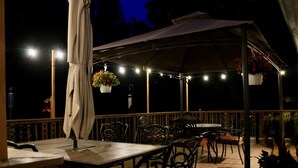 An outdoor patio area with a covered seating area, tables, and chairs. - Near Lake Michigan- Weko Beach | Private Setting | Beach Gear (Bridgman)