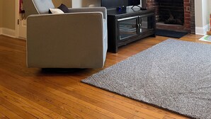 A living room with a fireplace, a television, a gray sofa, and a wooden floor. - Station House East: Upscale Loft in the Historic District Cambridge, MD (Cambridge)