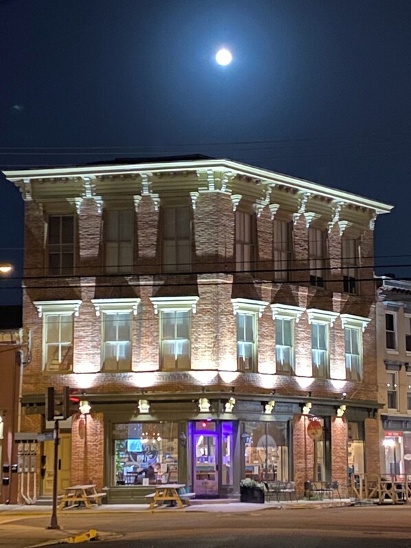 A multi-story building with a stone facade and illuminated windows at night.