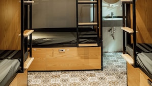 A compact, well-organized dormitory room with bunk beds, a small sink, and a ceiling fan. - Quiri Hostel Hanoi (Hanoi)