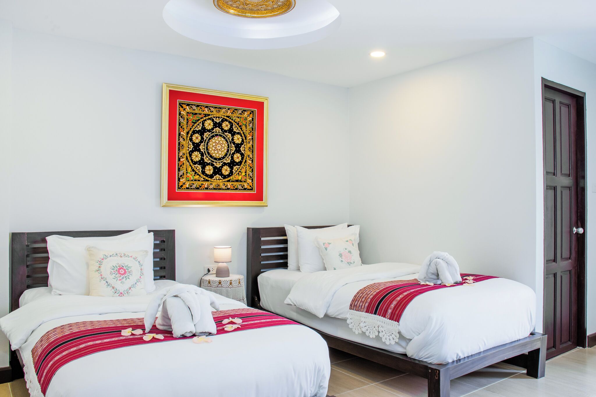 Une chambre d’hôtel avec deux lits, une décoration murale et une porte en bois.