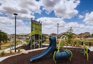 A playground with a slide, climbing structures, and exercise equipment.